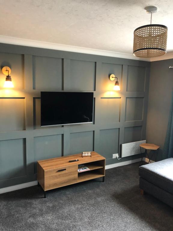 a living room with a flat screen tv on a wall at Sinclair Bay Apartments in Keiss