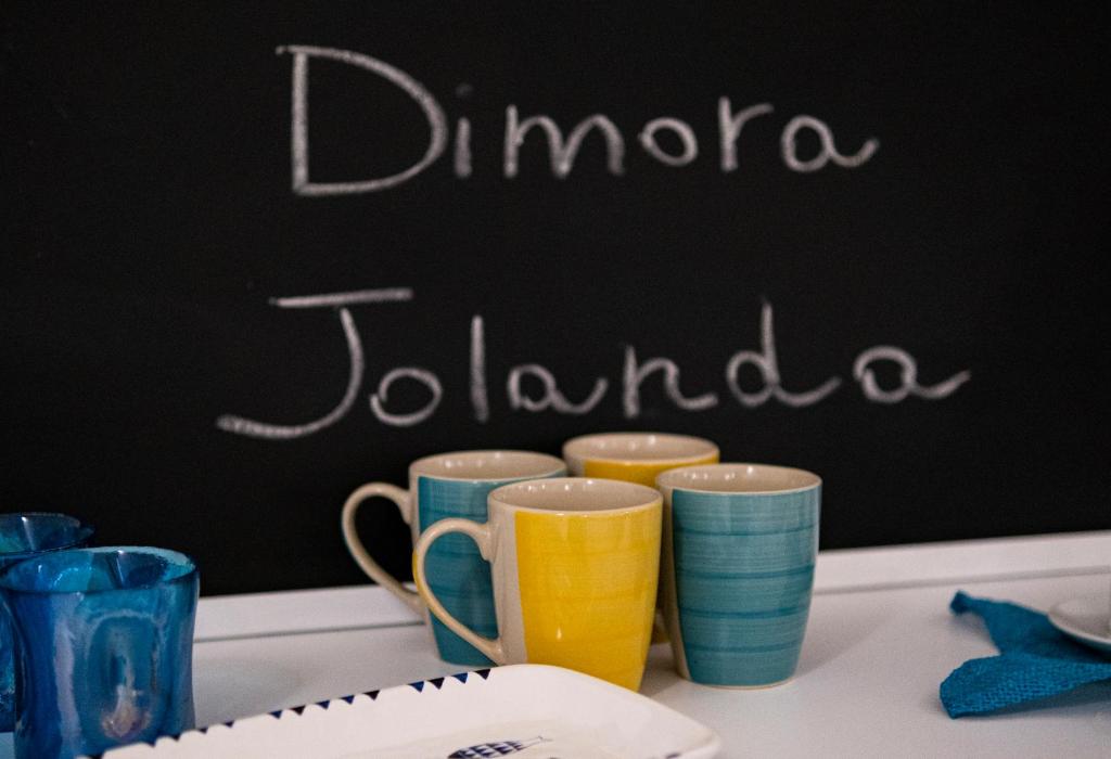 een groep kopjes op een tafel met een schoolbord bij Dimora Jolanda in Conversano