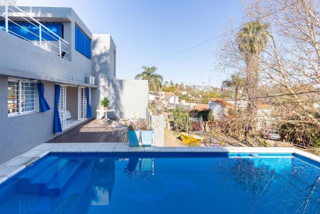 a blue swimming pool in front of a house at LA ARMONIA in Córdoba