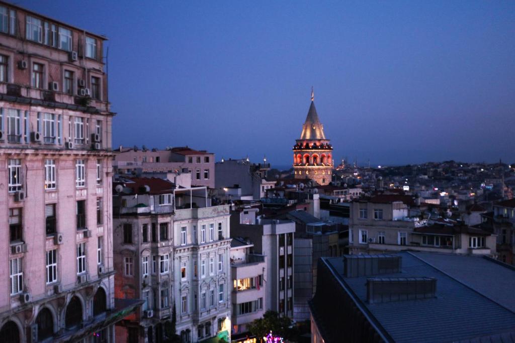 - une vue sur une ville la nuit avec une tour d'horloge dans l'établissement Medar Otel, à Istanbul