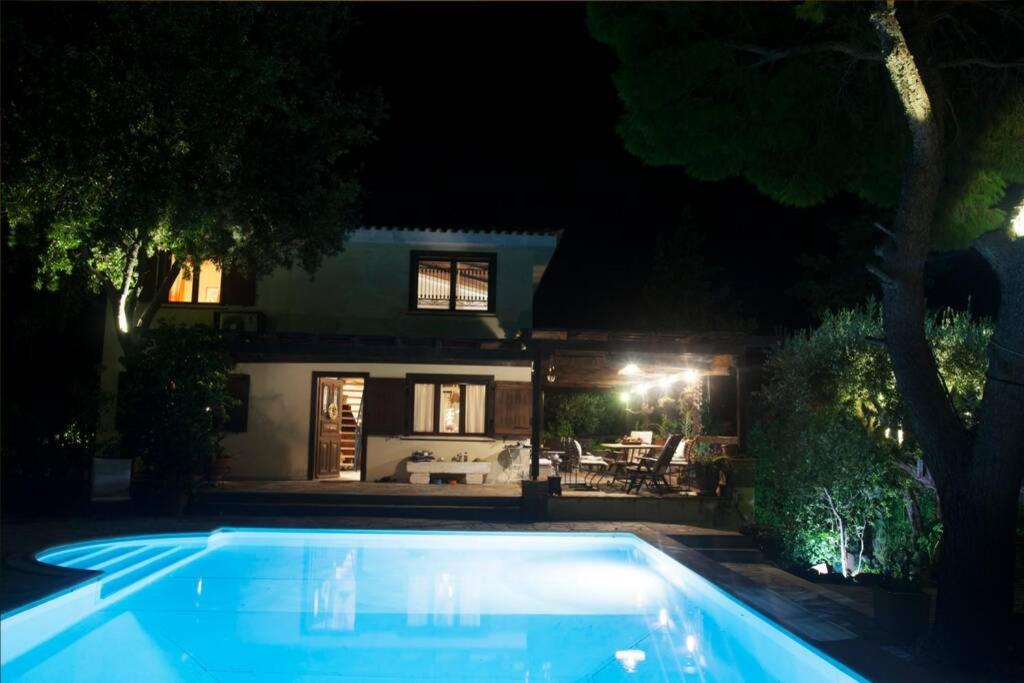 a swimming pool in front of a house at night at villa eleni in Sounio