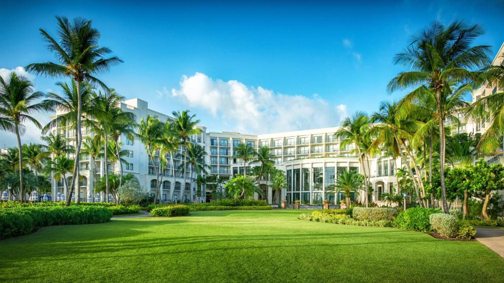 - une vue sur l'extérieur d'un complexe avec des palmiers et une pelouse dans l'établissement Margaritaville Vacation Club by Wyndham - Rio Mar, à Río Grande