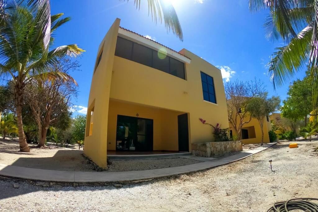 uma casa amarela com palmeiras em frente em Magnifica y comoda Villa 85 a 100 mts del Mar em Celestún