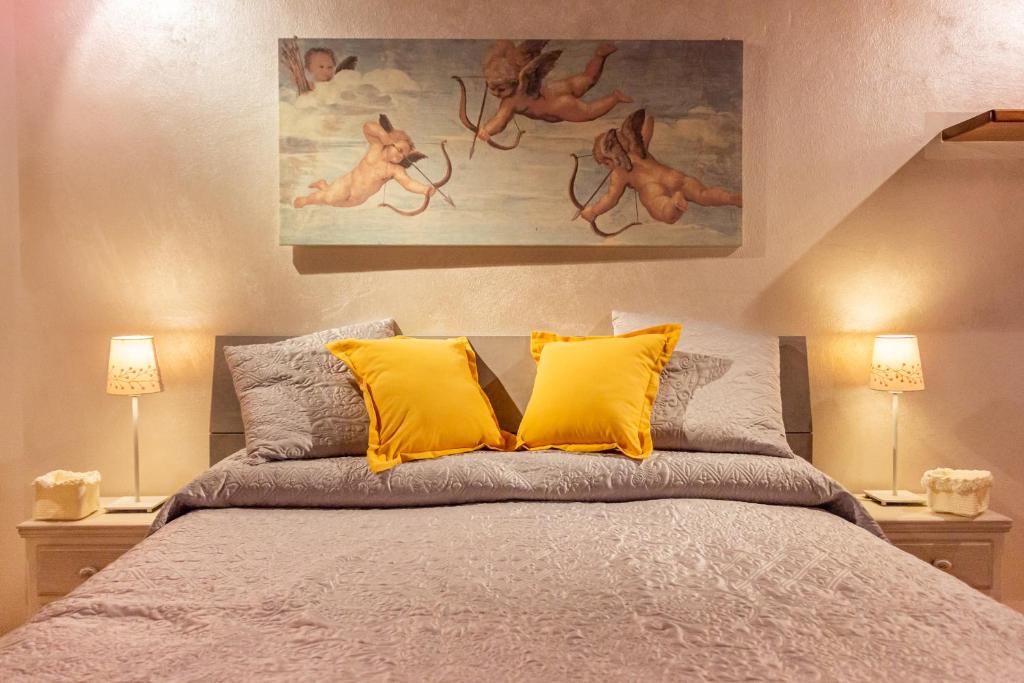 - une chambre avec un lit et 2 oreillers jaunes dans l'établissement Elena Casa Turistica, à Padoue