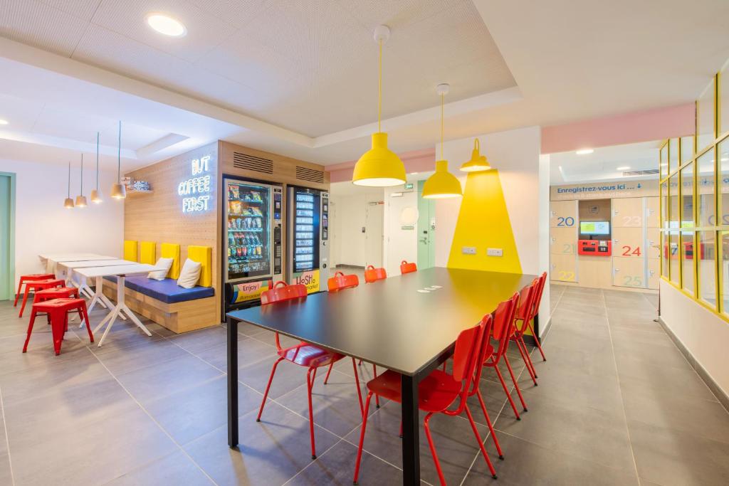 a dining room with a table and red chairs at Auberge de jeunesse Hosho Paris Sud - Porte d'Italie in Le Kremlin-Bicêtre