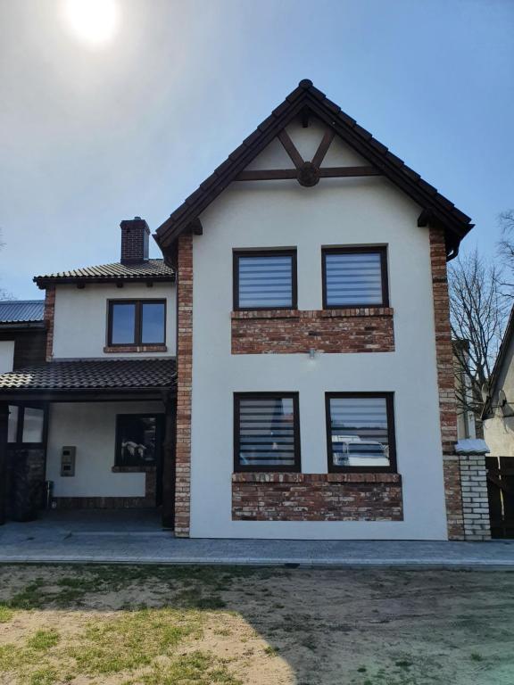 Casa blanca con ventanas negras en MTK Pokoje i Apartamenty, en Smołdzino
