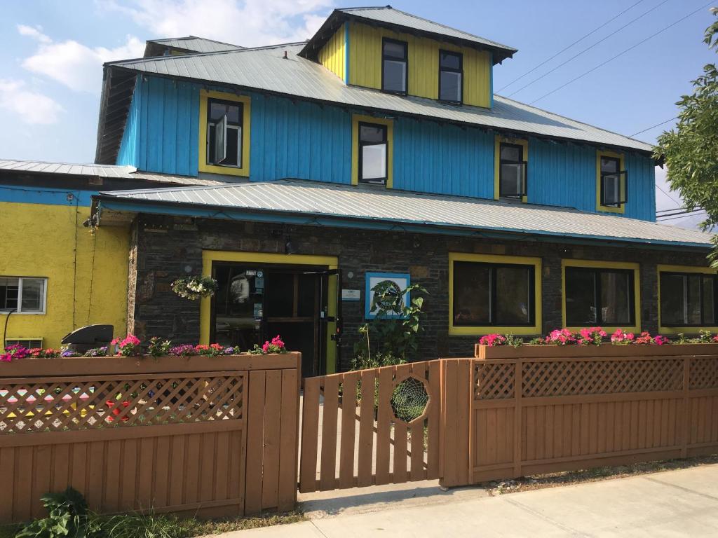 a house with a wooden fence in front of it at Dreamcatcher Hostel in Golden