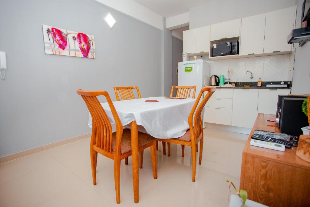 La cuisine est équipée d'une table, de chaises et d'un réfrigérateur. dans l'établissement Asuncion Soho - Departamentos, à Asuncion