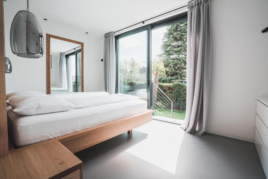 sypialnia z łóżkiem i dużym oknem w obiekcie Montelino Boutiquehouse w mieście Bardolino