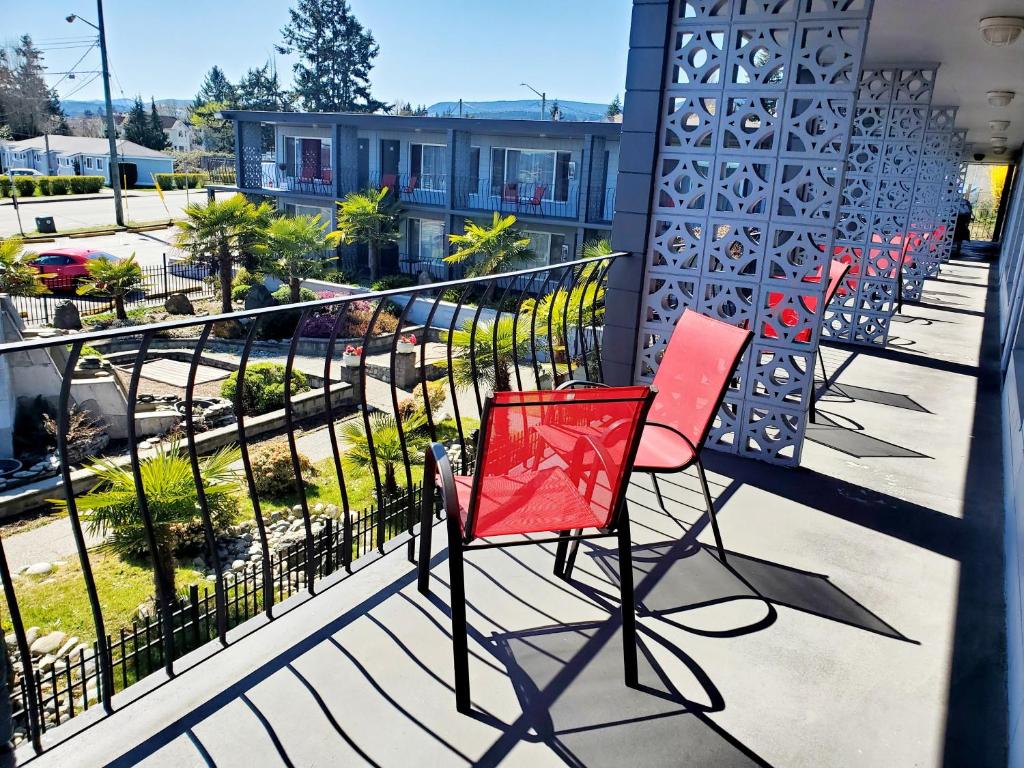 para czerwonych krzeseł siedzących na balkonie w obiekcie Port-O-Call Inn w mieście Nanaimo
