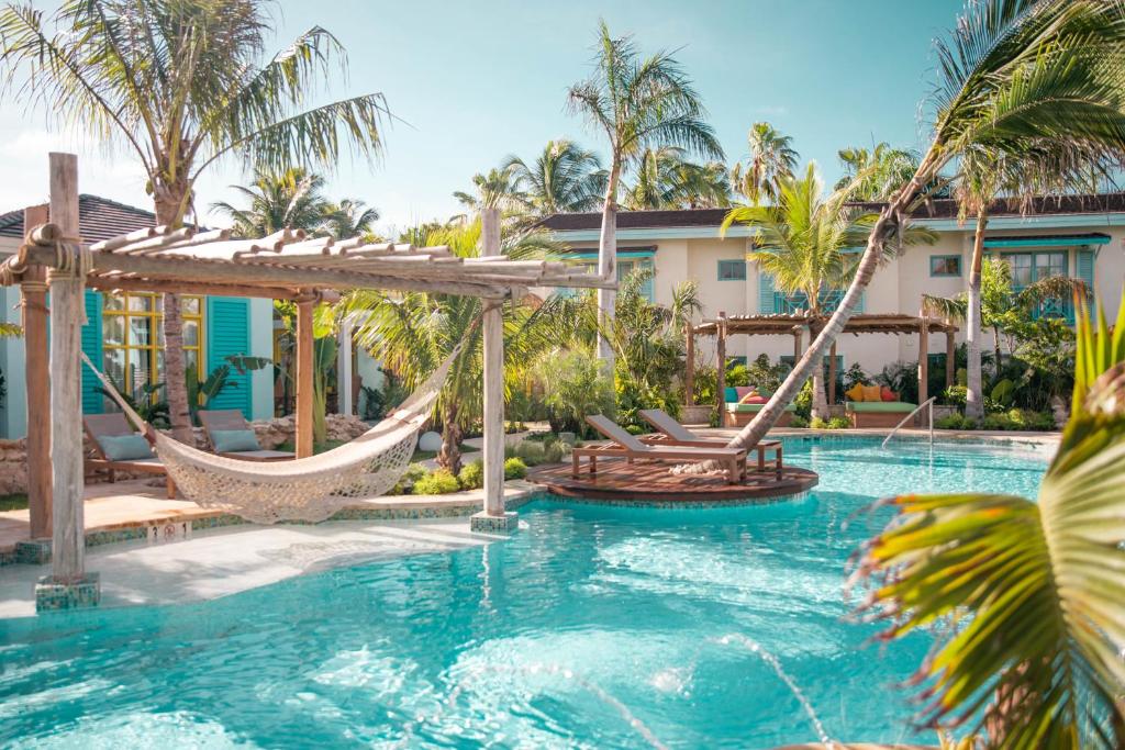 - une piscine avec un hamac et un complexe dans l'établissement Boardwalk Boutique Hotel Aruba - Adults Only, à Palm-Eagle Beach
