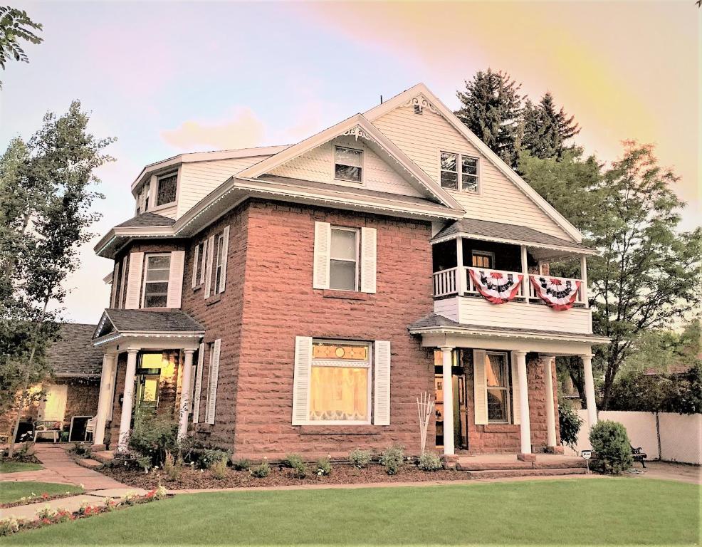 uma casa de tijolos com um alpendre e uma varanda em Heber Senator Bed and Breakfast em Heber City