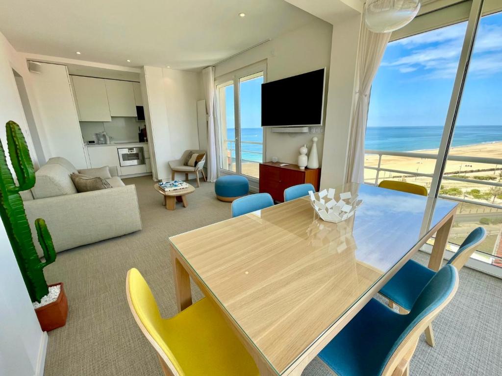 una sala da pranzo con tavolo, sedie e vista sull'oceano di Vue superbe sur l’océan, la plage à vos pieds ! a Soorts-Hossegor