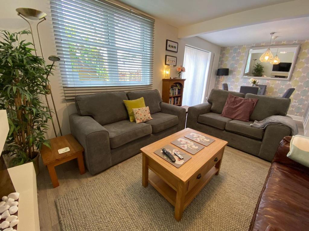 a living room with two couches and a coffee table at Meadowside Cottage in Bassenthwaite Lake