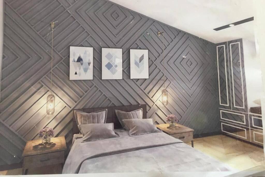 um quarto com uma cama grande e uma parede de madeira em New apartment em Samarkand