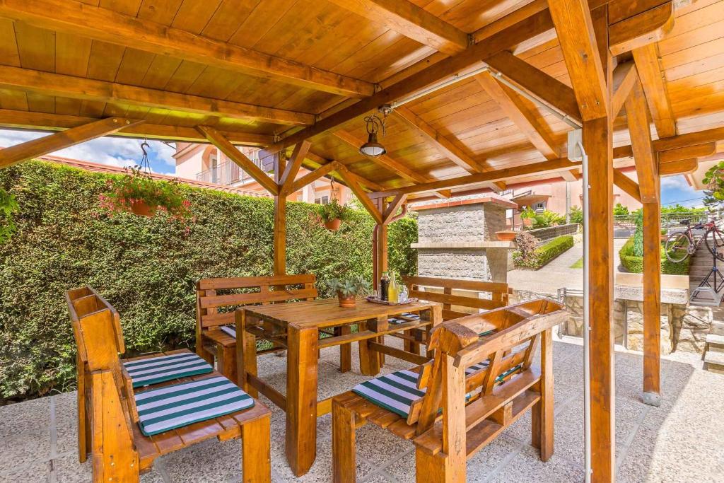 drewniany stół piknikowy i krzesła pod drewnianą pergolą w obiekcie Apartment in Viskovo 31060 w mieście Viskovo