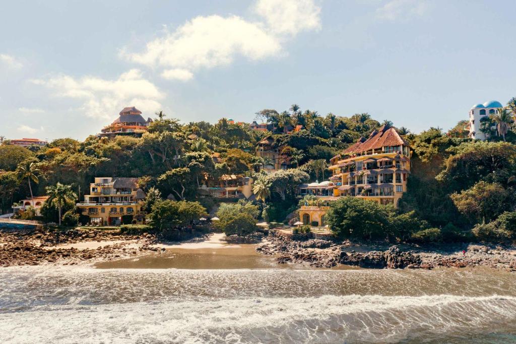 um resort numa colina ao lado de um corpo de água em Villa Amor em Sayulita