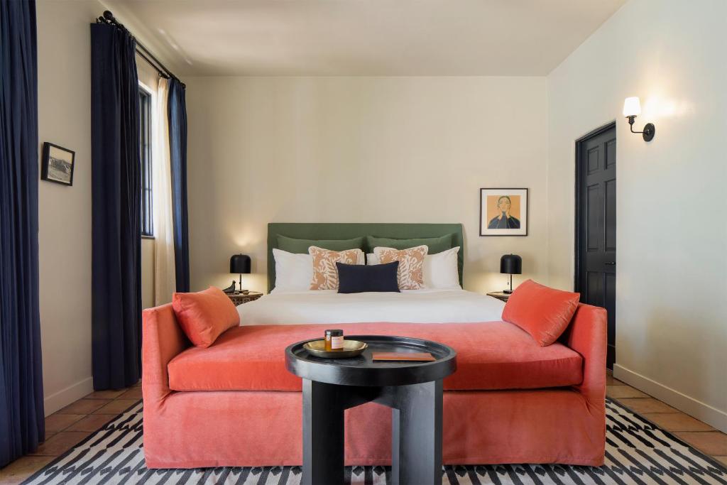 ein Schlafzimmer mit einem Bett und einem roten Sofa in der Unterkunft Casa Cody in Palm Springs