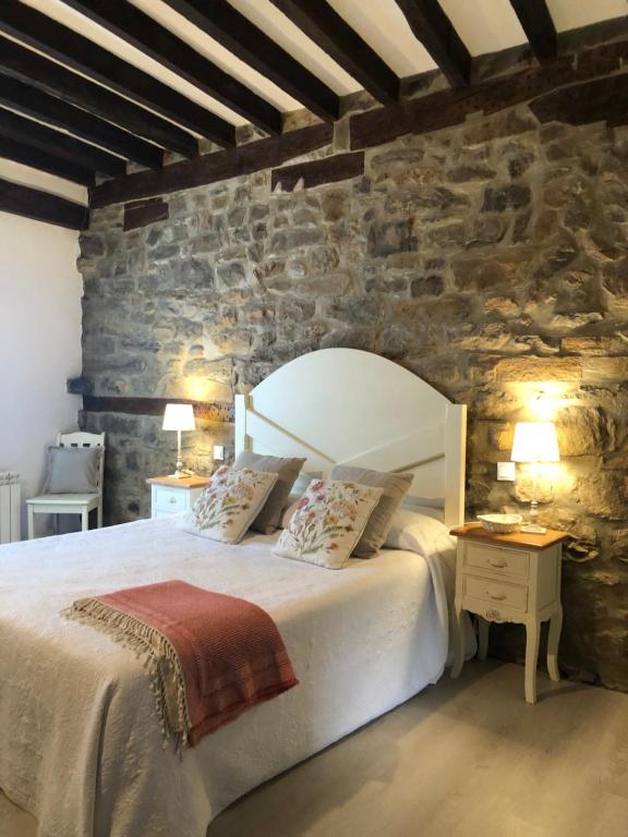 a bedroom with a large bed and a stone wall at Villa Solana in Potes