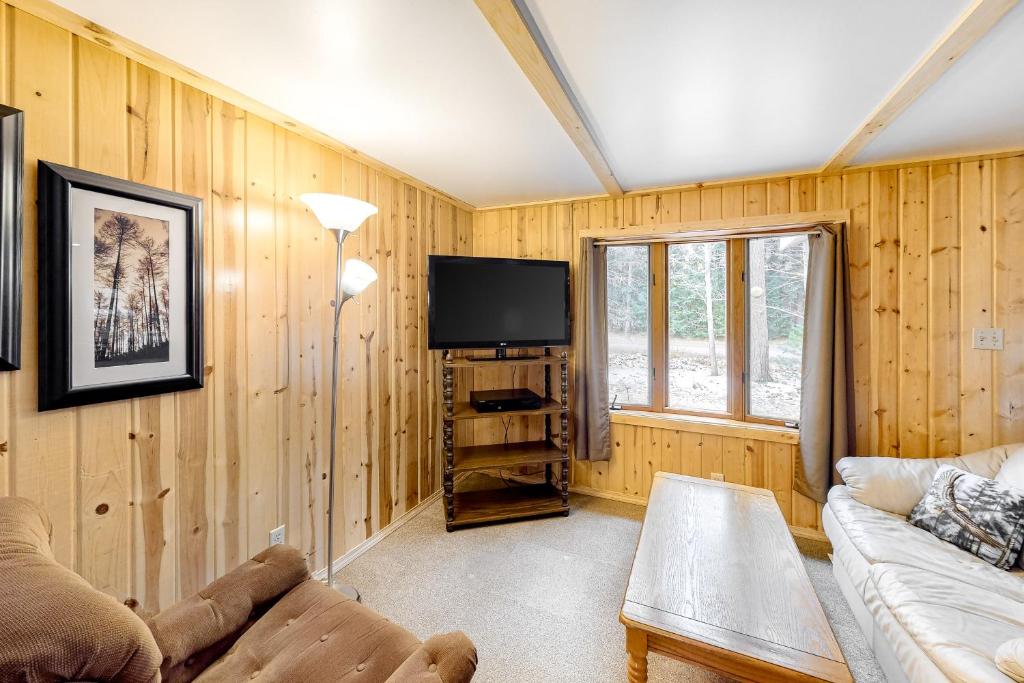 a living room with a couch and a flat screen tv at Quaint Lake Escape in Eagle River