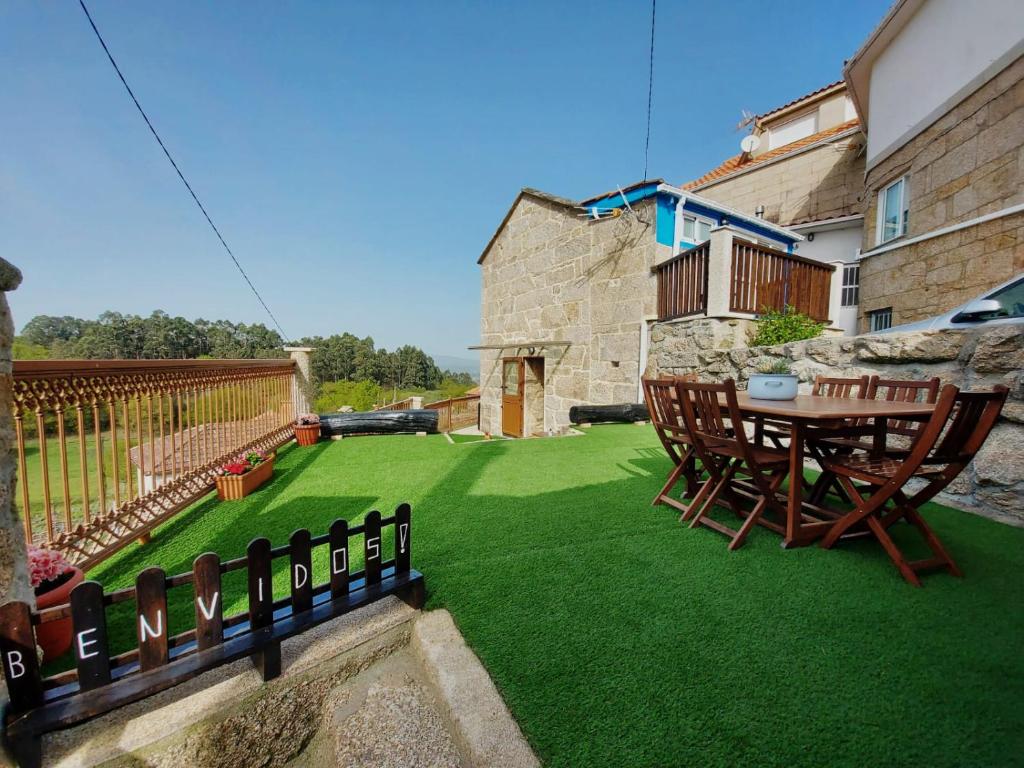 a patio with a table and chairs on a lawn at A Casiña do Xastre in Pontevedra