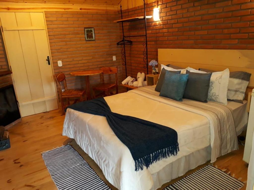 a bedroom with a large bed in a room at Pousada Casa da Vista in Visconde De Maua
