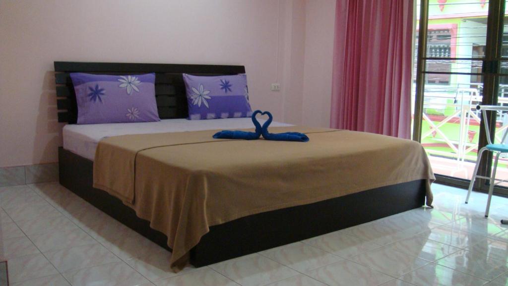 Un dormitorio con una cama con una cinta azul. en Candy House, en Patong Beach