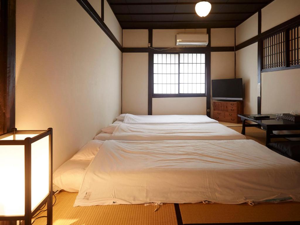 Postel nebo postele na pokoji v ubytování Takeyaso Ryokan