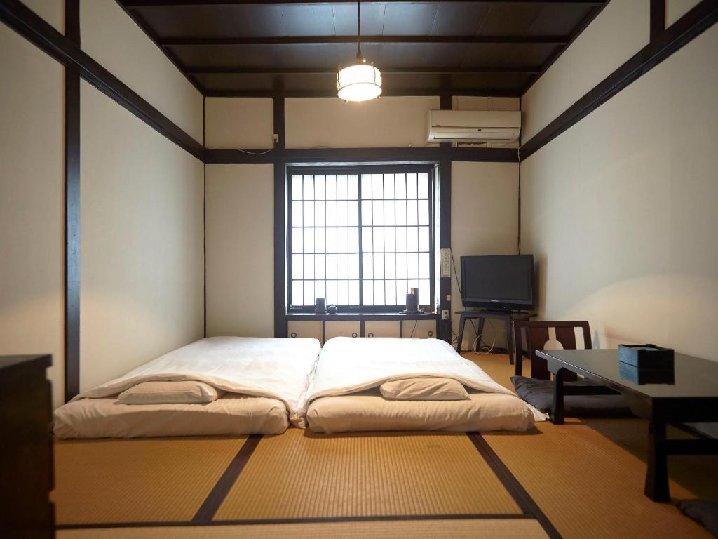Postel nebo postele na pokoji v ubytování Takeyaso Ryokan