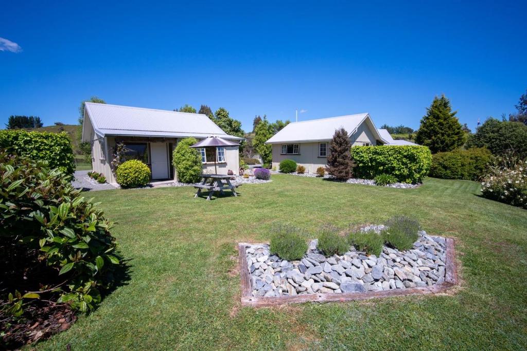 una casa con un patio con un jardín de rocas en Blue Thistle Cottages en Te Anau