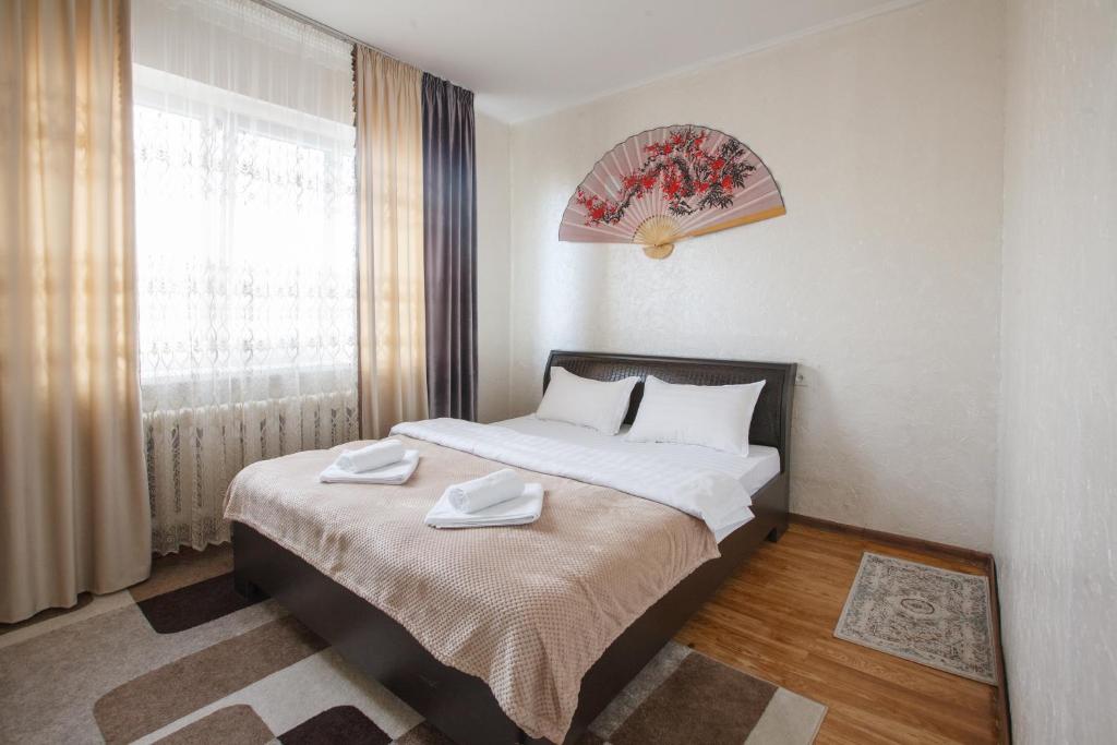 a bedroom with a bed with two towels on it at Квартира на Пушкина in Almaty