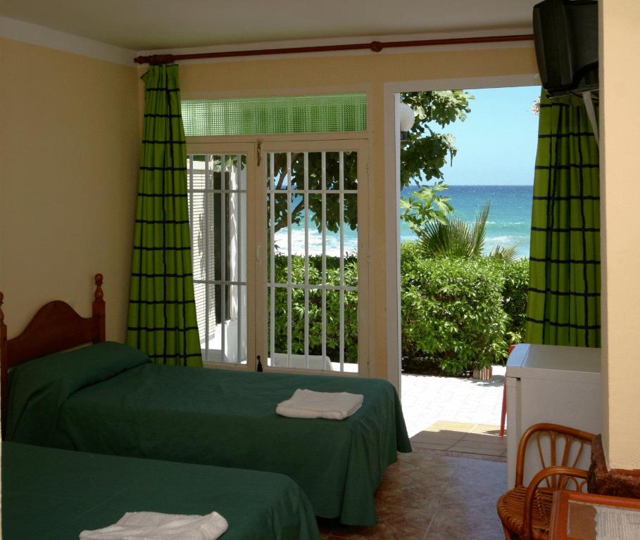 a bedroom with two beds and a view of the ocean at Hotel Playa in Mojácar