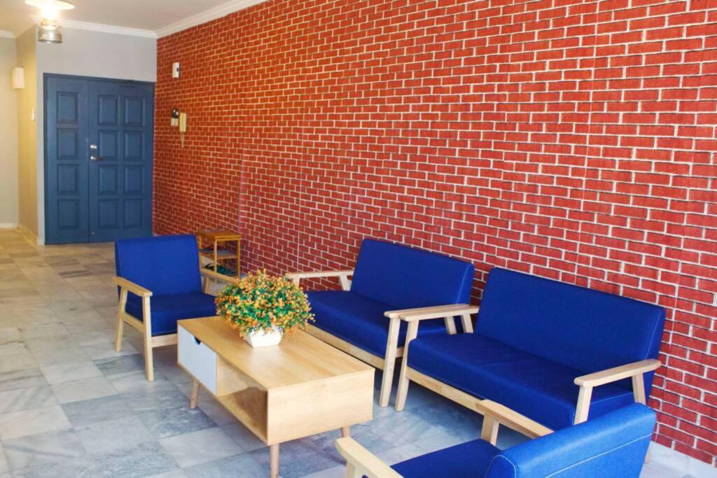 two blue chairs and a table and a brick wall at 50% off! Axiata Arena/BUKIT JALIL/LRT! cosy 3BR in Kuala Lumpur