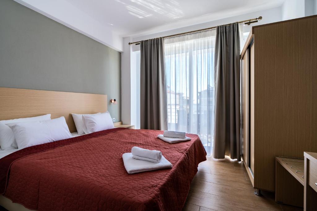 a hotel room with a bed with two towels on it at Novelrooms in Paralia Katerinis