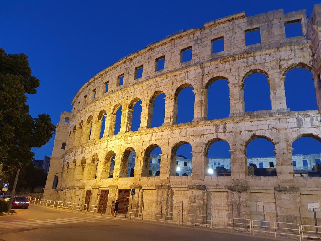 una vista del coliseo por la noche en Amphitheater Apartment en Pula