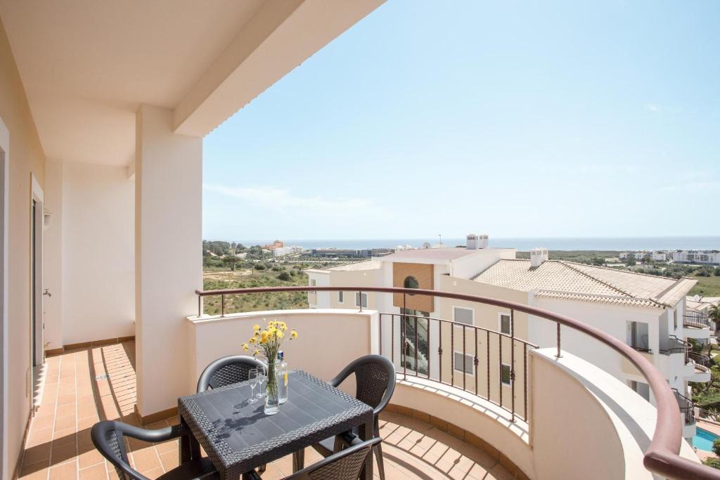 een balkon met een tafel en uitzicht op de oceaan bij Meia Praia Beach Apartment in Lagos