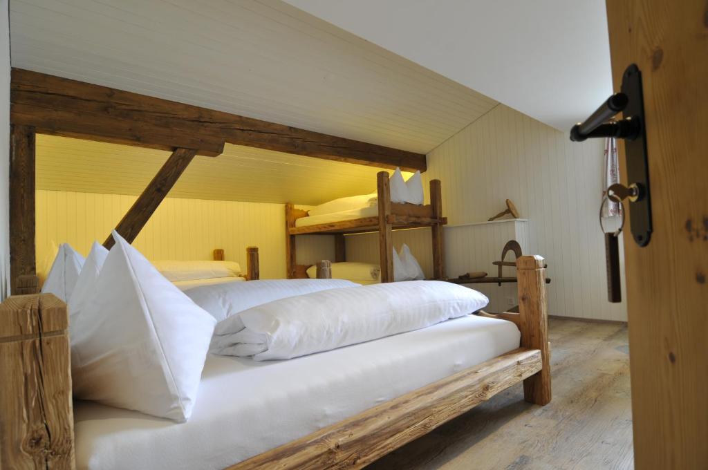 1 dormitorio con 2 camas y almohadas blancas en Berglodge Ristis en Engelberg