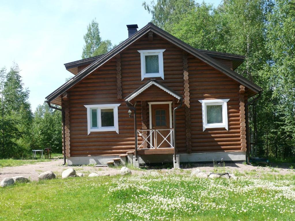 Cabaña de madera con porche y puerta en Villa Pyhalto, en Ylä-Jääski