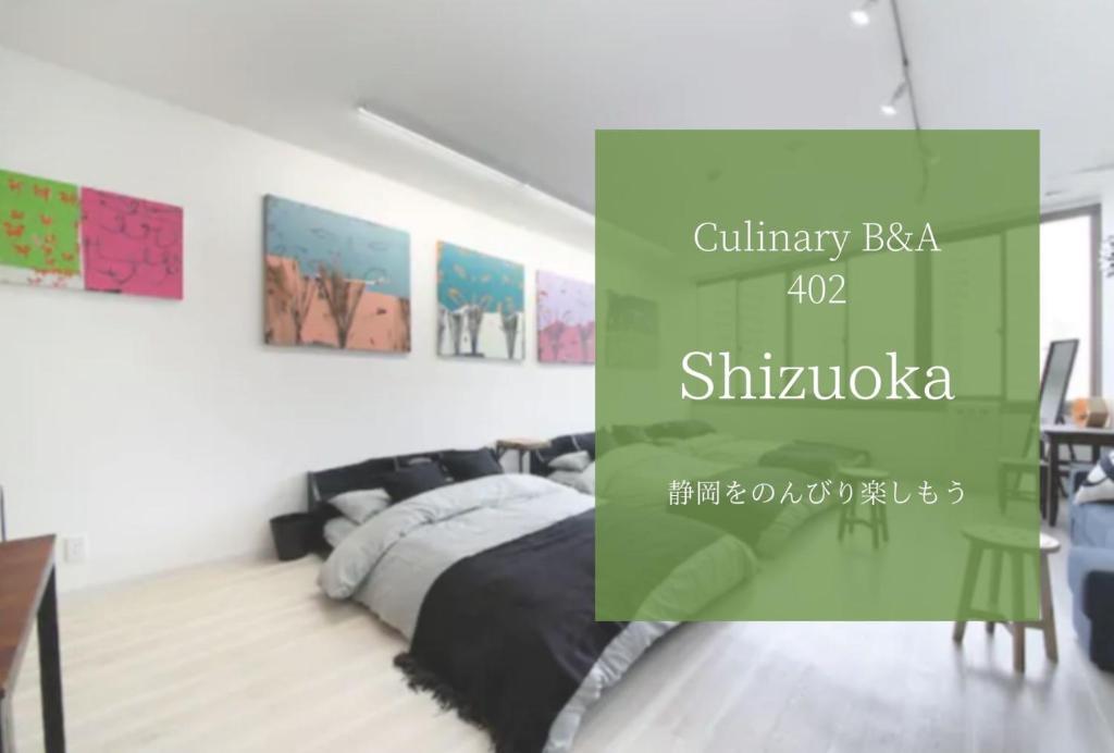 1 dormitorio con 1 cama y pinturas en la pared en Culinary Bed&Art 402, en Hamamatsu