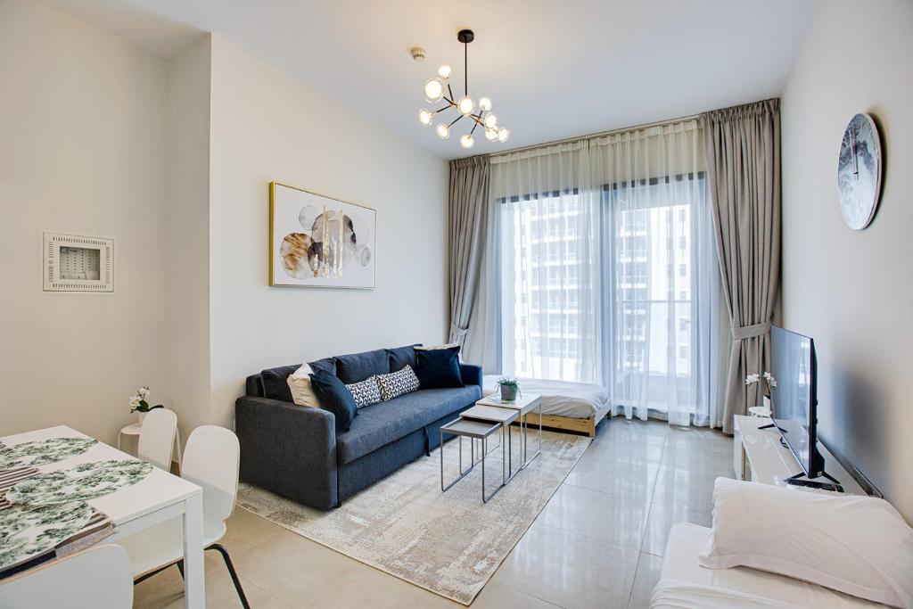 a living room with a couch and a tv at 5* Brand New Sparkle Tower by Swarovsky in Dubai