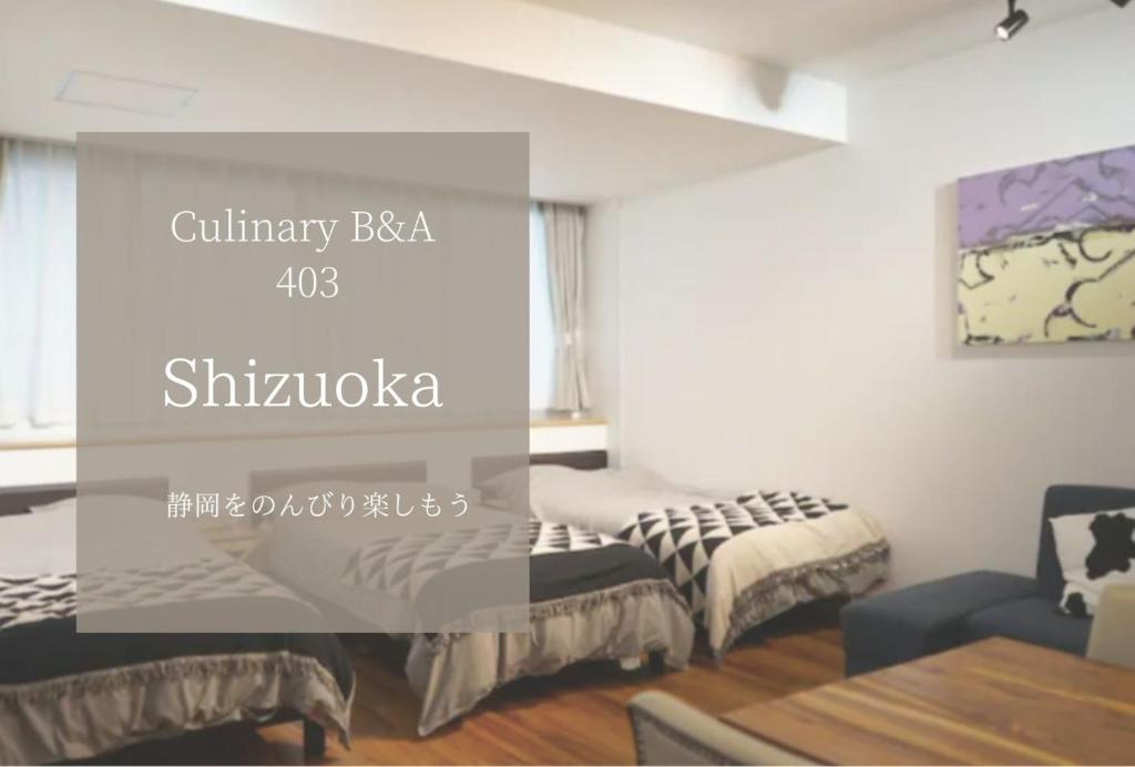 salon z 2 łóżkami i stołem w obiekcie Culinary Bed&Art2 403 w mieście Hamamatsu