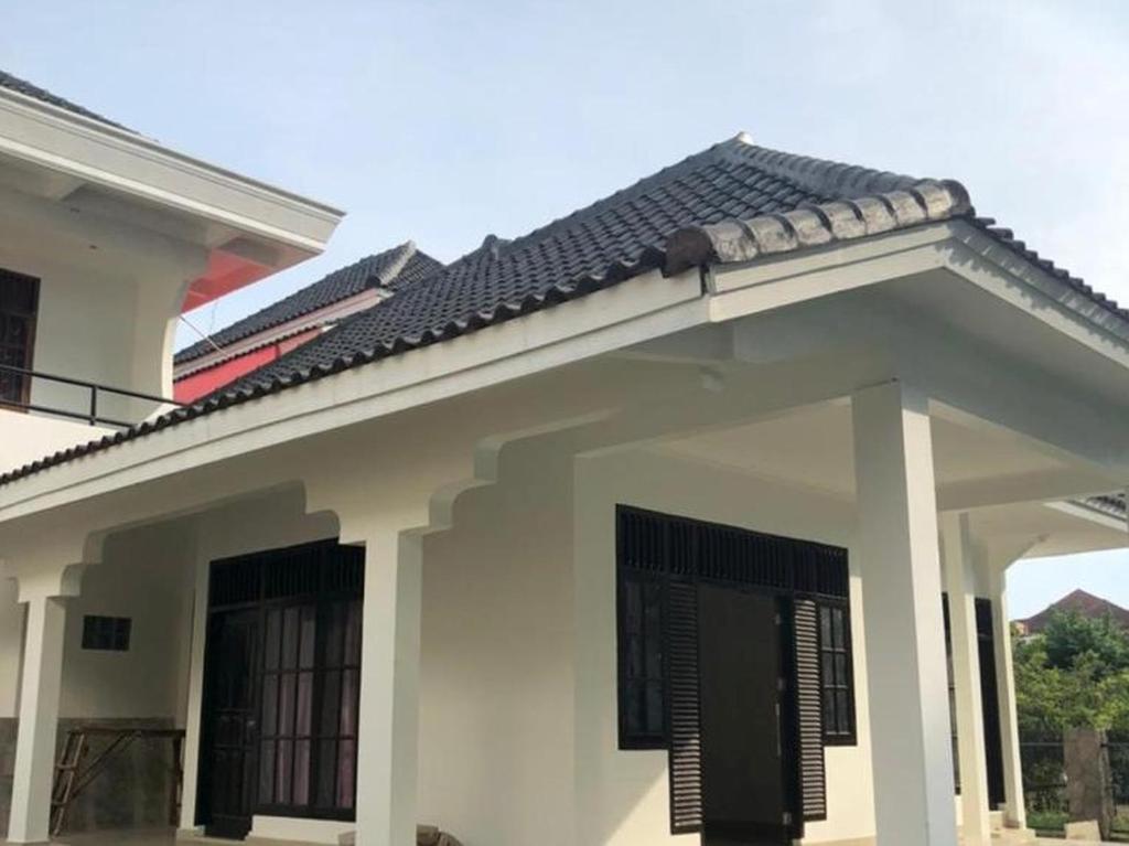 Lampung的住宿－RedDoorz near Politeknik Negeri Lampung，黑色屋顶的白色房子