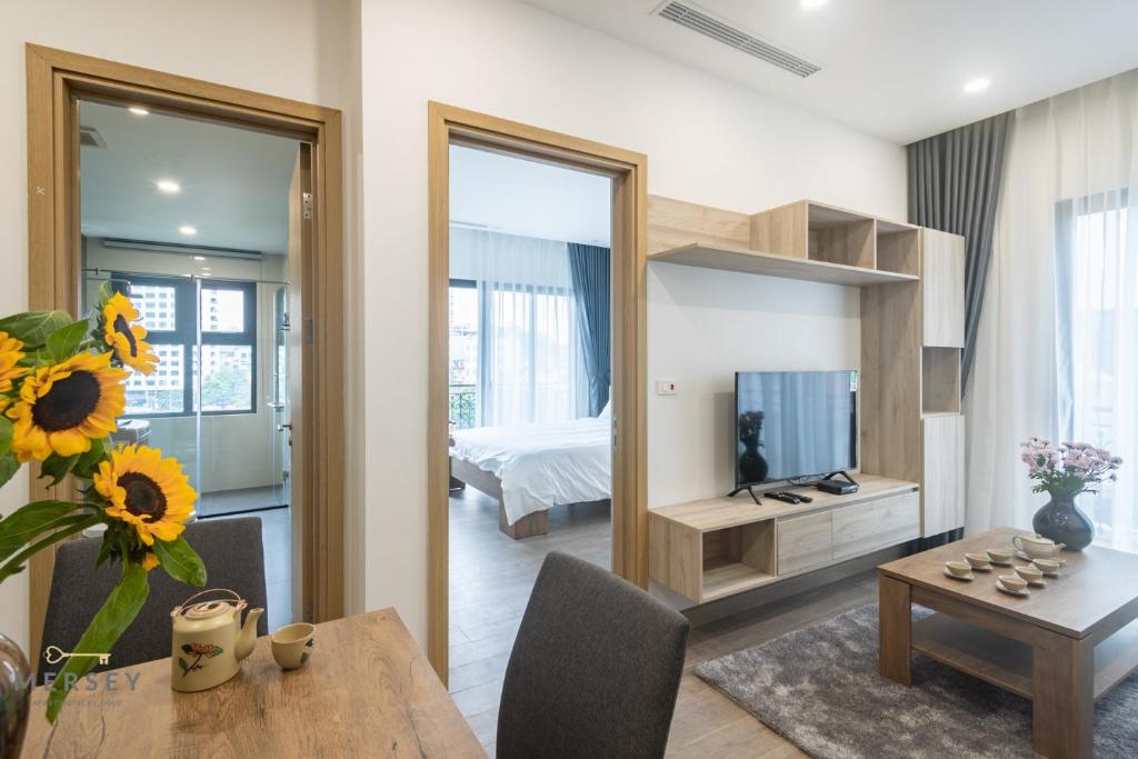 1 dormitorio y sala de estar con mesa de comedor. en Mersey Central Hanoi Apart'Hotel en Hanoi