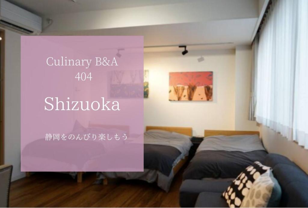 濱松的住宿－Culinary Bed&Art 404，一间设有两张床的客房,墙上有标志