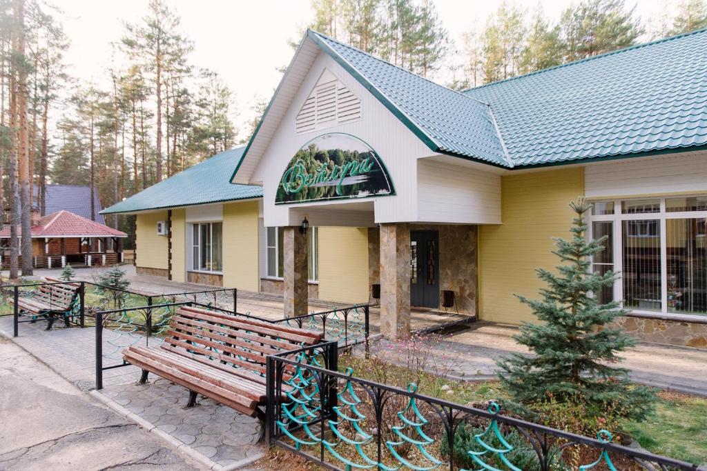 a yellow building with a bench in front of it at База отдыха "Ветлуга" in Shar'ya