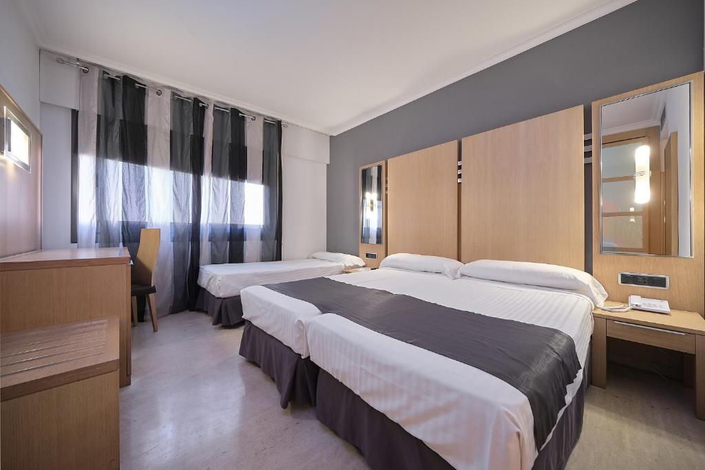 サンシェンショにあるHotel Faro Salazónのベッド2台とテレビが備わるホテルルームです。