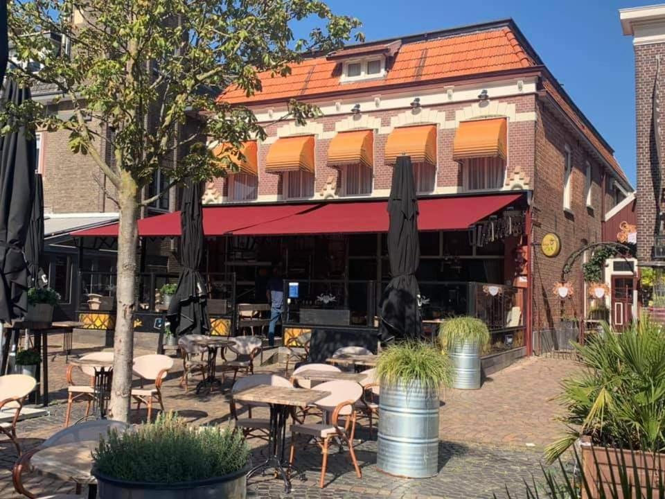 an outdoor patio with tables and chairs in front of a building at BijHillen in bed in Winterswijk