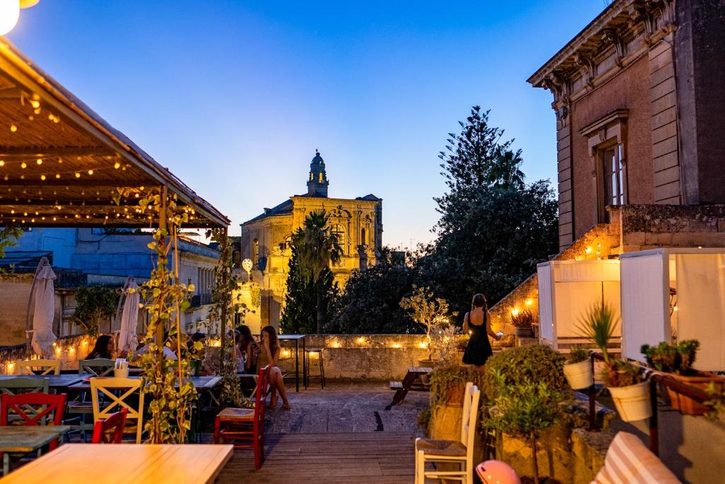 un patio avec des tables et des chaises et un bâtiment dans l'établissement Dimora San Giuseppe, à Lecce