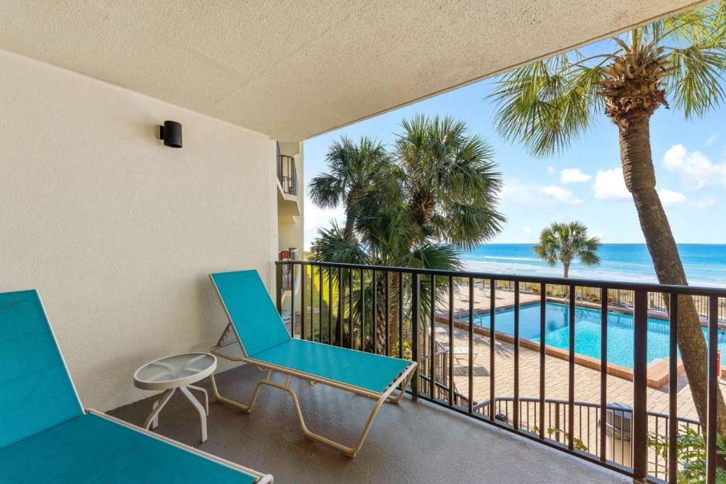 una sedia blu su un balcone con vista sulla spiaggia di Commodore 206 a Panama City Beach
