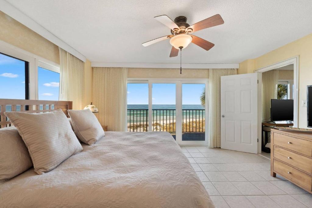 パナマ・シティ・ビーチにあるCommodore 201のベッドと天井扇風機のある寝室